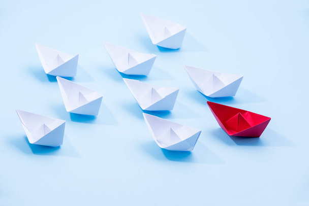 Красно-белые бумажные лодки. Концепция лидерских лодок для групповой работы или успеха. - Фото, изображение