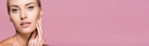 mooie blonde vrouw met perfecte huid aanraken gezicht geïsoleerd op roze, banner - Foto, afbeelding