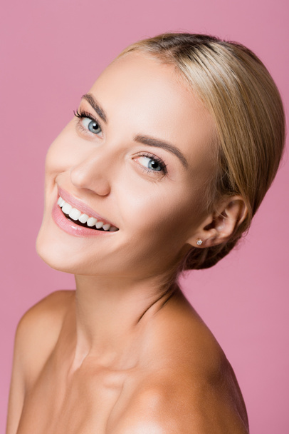 χαμογελαστή όμορφη ξανθιά γυναίκα με τέλειο δέρμα απομονωμένο σε ροζ - Φωτογραφία, εικόνα