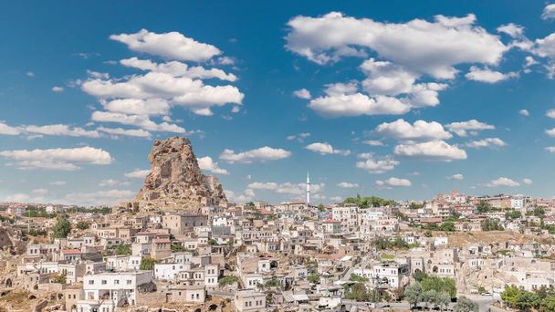 View of Ortahisar town old houses in rock formations from Ortahisar Castle aerial timelapse. Cappadocia. Nevsehir Province. Turkey. Cloudy blue sky - Foto, afbeelding