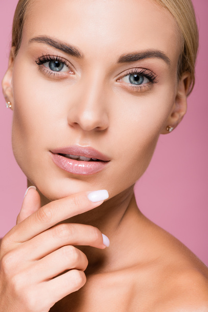 beautiful blonde woman with perfect skin touching face isolated on pink - Valokuva, kuva