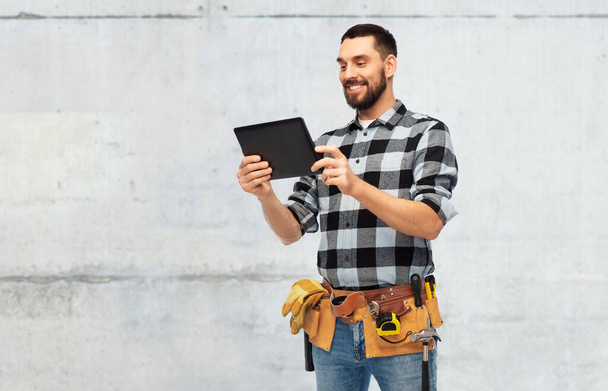 happy builder with tablet computer and tools - 写真・画像