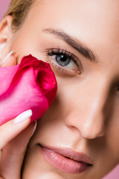 closeup όμορφη ξανθιά γυναίκα με τέλειο δέρμα και τριαντάφυλλο λουλούδι που απομονώνονται σε ροζ - Φωτογραφία, εικόνα