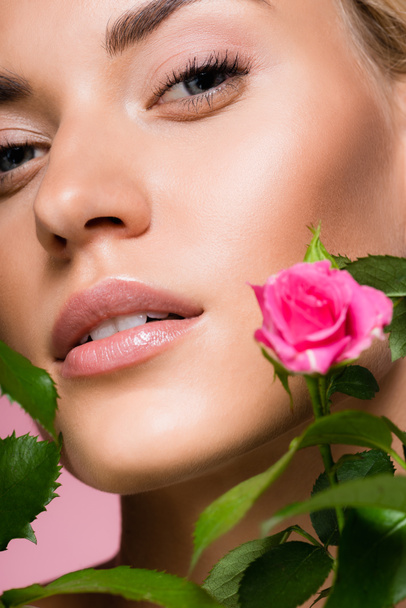 beautiful blonde woman in rose flowers isolated on pink - Foto, imagen