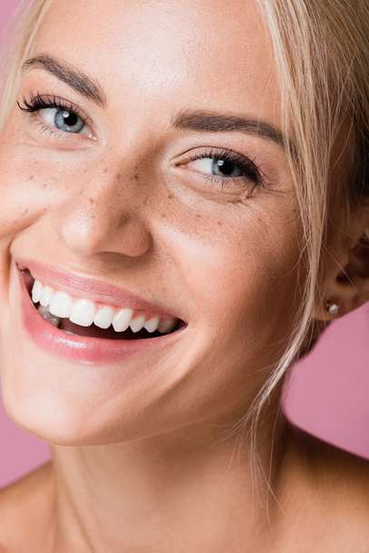 glimlachen mooie blonde vrouw met sproeten geïsoleerd op roze - Foto, afbeelding