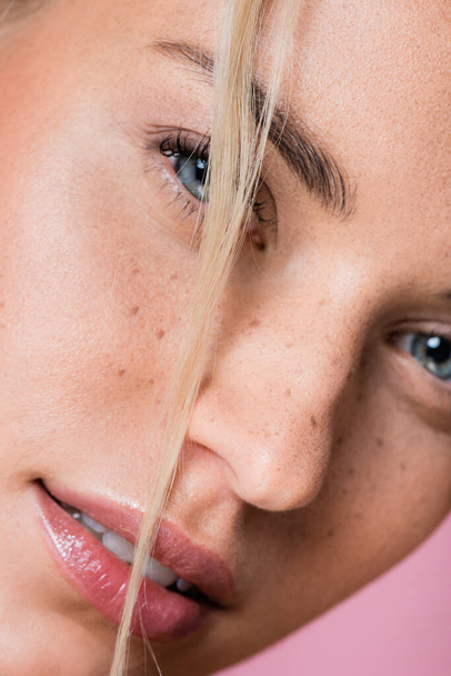 closeup of beautiful blonde woman with freckles isolated on pink - Фото, изображение