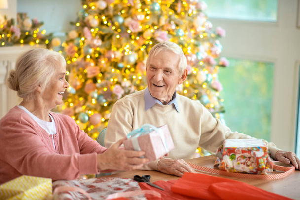 Elderly couple preparing christmas presents and feeling good - Fotó, kép