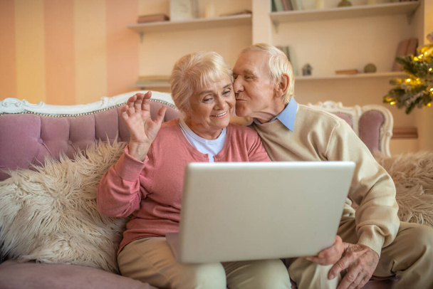 Senior couple having a video call and feeling happy - Фото, изображение