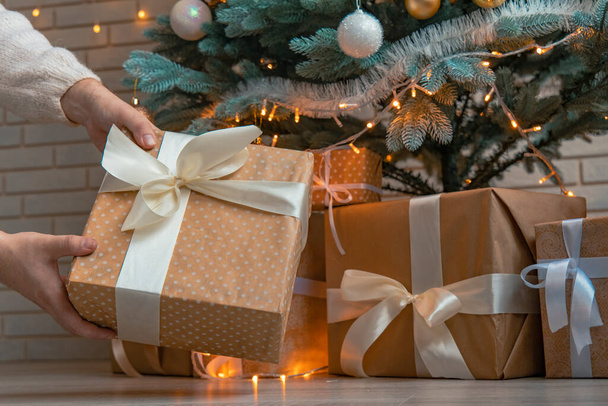 Рождественский подарок под елку теплые и уютные зимние праздники вид изнутри с гирляндой лампы огни - Фото, изображение