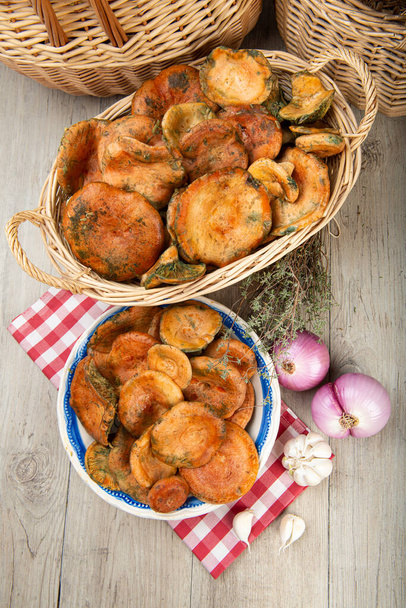Šafránové mléčné čepice nebo červené borové houby v koších a miskách na kuchyňském stole - Fotografie, Obrázek