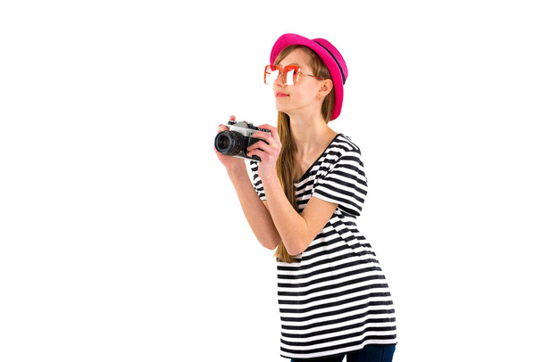 Happy hipster girl holding vintage camera in studio white isolated background.Side view - Foto, Imagen