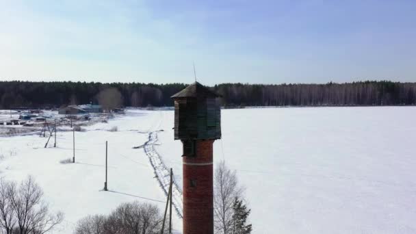 Dolly zoom. Voando no inverno. Torre de água velha em um campo coberto de neve - Filmagem, Vídeo