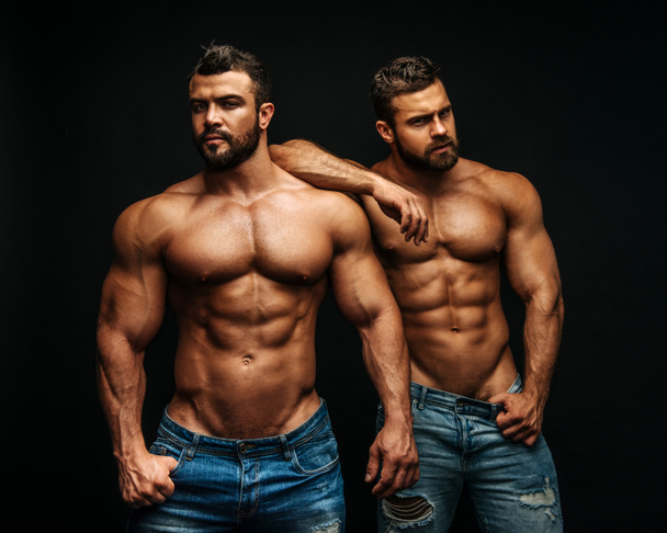 Two hunks standing at black background - Photo, Image