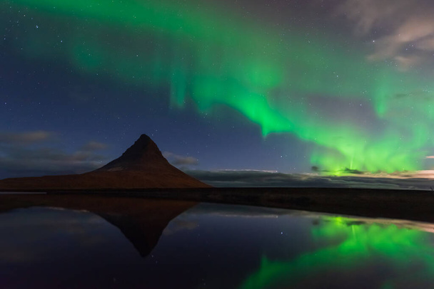 İzlanda 'nın kuzey ışıkları. Kp5 Aurora Borealis ile dolu bir manzara. Kirkjufell 'de muhteşem bir gece manzarası, manzaralı bir seyahat yeri. Yıldızlarla dolu yeşil gökyüzü. - Fotoğraf, Görsel