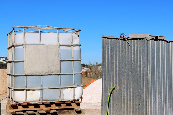 Большой пластиковый контейнер, армированный сталью для хранения воды на строительных площадках. - Фото, изображение