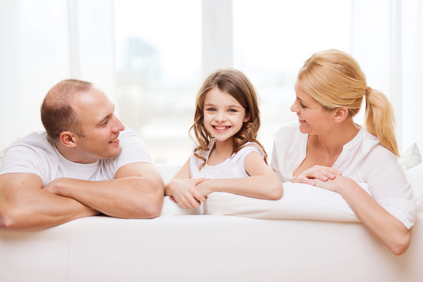 Smiling parents and little girl at home - Foto, imagen