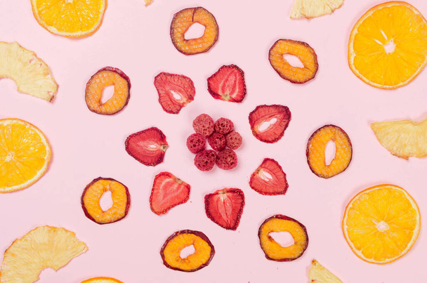 Dried slices of different fruits chips scattered on pink background. Assorted Fruit chips. Healthy eating concept, snack, no sugar. Top view, copy space.  - Fotoğraf, Görsel