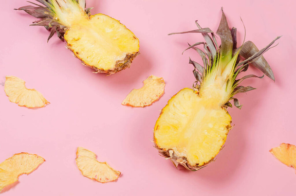 Ripe juicy pineapple on pink background and dried pineapple wedges around. Fruit chips. Healthy eating concept, snack, no sugar. Top view, copy space. - Photo, image