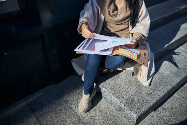 Elegant woman studying documents on the street - Valokuva, kuva