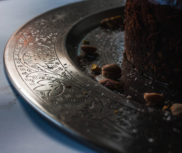 Decorações árabes cintilantes em uma placa metálica com um cheesecake de chocolate - Foto, Imagem