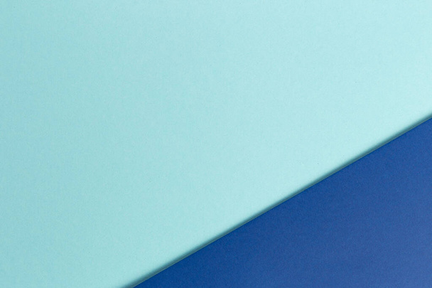Material Design blauer Hintergrund. Bastelpapierbögen werden auf unterschiedliche Weise gefaltet. Ein Foto - Foto, Bild