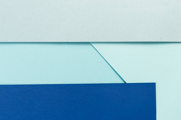Material design blue background. Craft paper sheets are folded in different ways. A photo - Foto, Bild