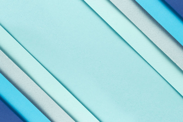 Material design blue background. Craft paper sheets are folded in different ways. A photo - Foto, afbeelding