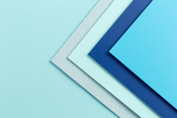 材料設計青の背景。クラフト紙シートはさまざまな方法で折り畳まれています。写真 - 写真・画像