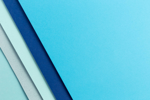 Material design blue background. Craft paper sheets are folded in different ways. A photo - Zdjęcie, obraz
