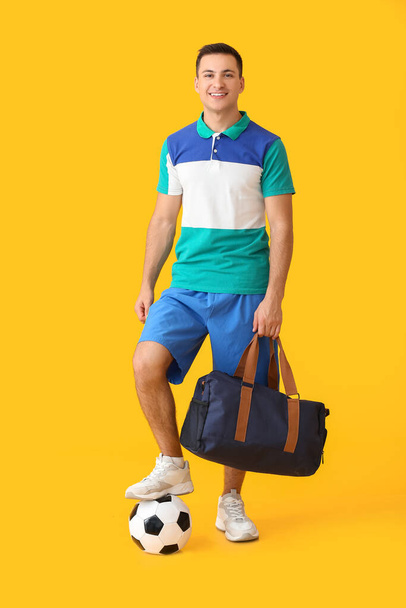 Football player with soccer ball and bag on color background - Fotó, kép