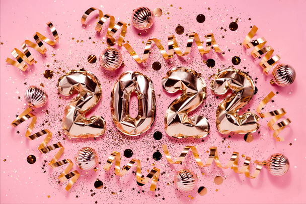 Εορταστική Πρωτοχρονιά Flatlay φόντο ροζ χρυσό αλουμινόχαρτο μπαλόνια και χρυσές διακοσμήσεις. Κορυφαία οριζόντια άποψη copyspace. - Φωτογραφία, εικόνα