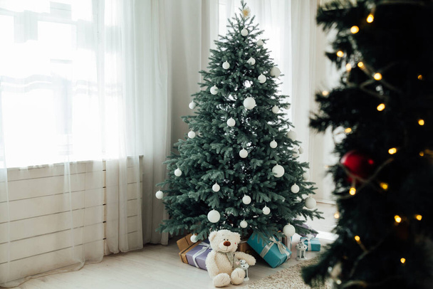 New Years decoration Christmas tree with gifts and garlands interior - Photo, Image