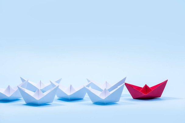 Red and white paper boats. Concept of leadership boats for teamwork group or success. - Foto, imagen