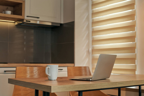 Телекоммуникационное рабочее пространство с ноутбуком и чашкой кофе - избирательный фокус - Фото, изображение