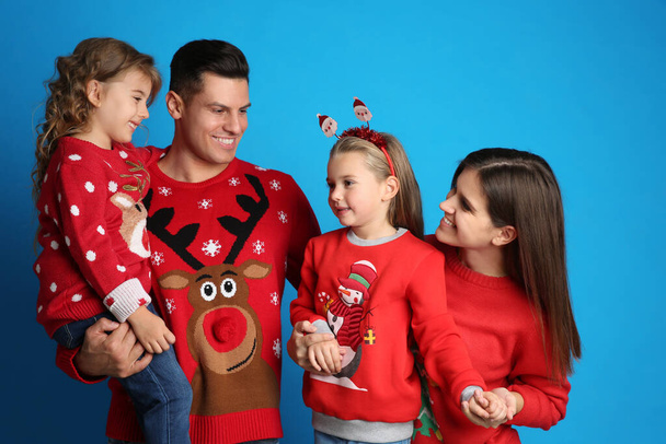 Family in Christmas sweaters on blue background - Zdjęcie, obraz
