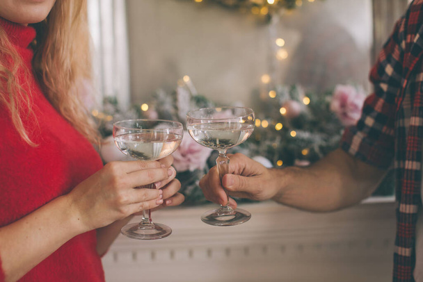 mladý krásný pár slaví Vánoce doma v útulném oblečení a pití šampaňského - Fotografie, Obrázek
