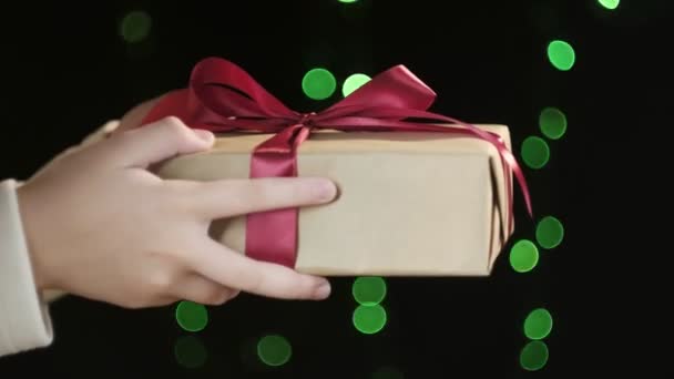 persone mani dando Natale o scatola regalo di compleanno con nastro rosso per l'uomo - Filmati, video