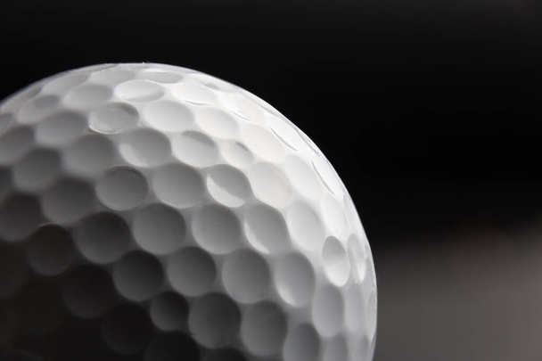 golf ball seen very close. Black background - Photo, Image