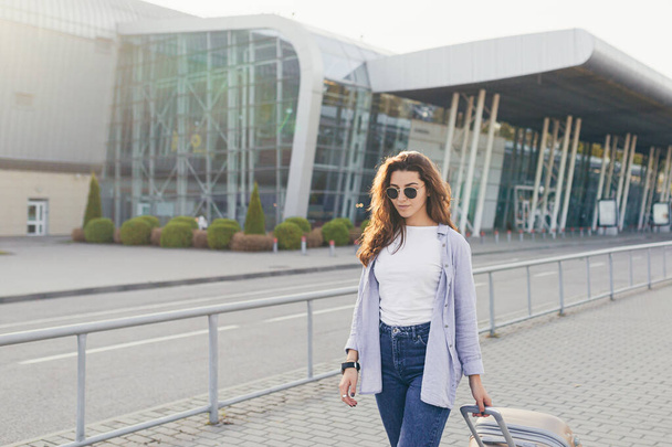 Mladá krásná dívka student opustí letiště v novém městě, a čeká na taxi - Fotografie, Obrázek