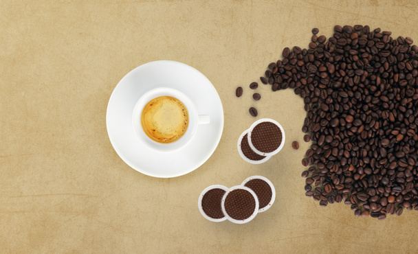 Чашка кофе с бобами, кофейные стручки на мраморном столе
 - Фото, изображение