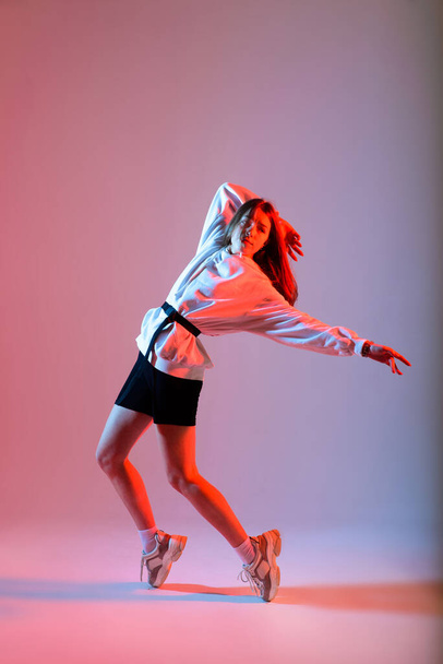 Young beautiful dancer posing on studio background - Foto, imagen
