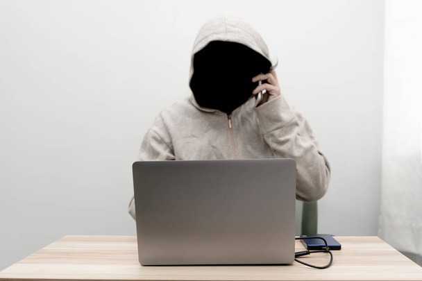 O Coringa das Sombras usa um laptop para roubar informações. - Foto, Imagem