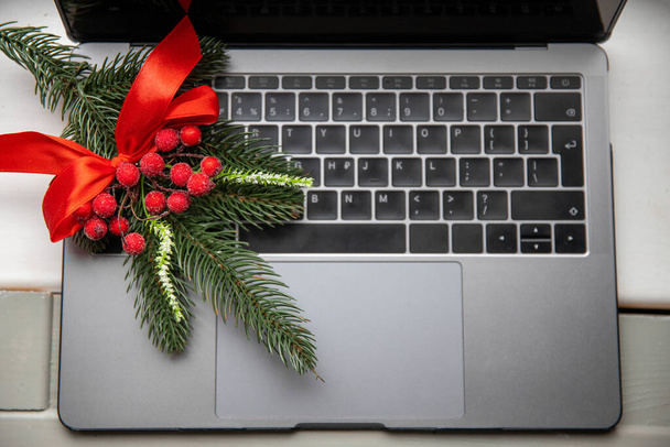 Online christmas shopping concept with laptop keyboard and pine. Top view. - Фото, изображение