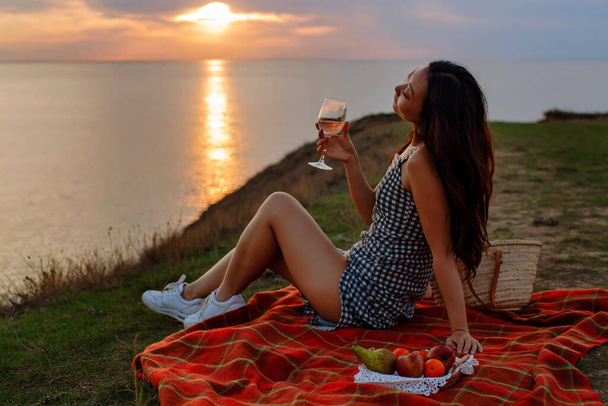 Beautiful Woman Enjoying Nature With Wine Outdoors At Sunset In Top Of Hill. - Photo, Image