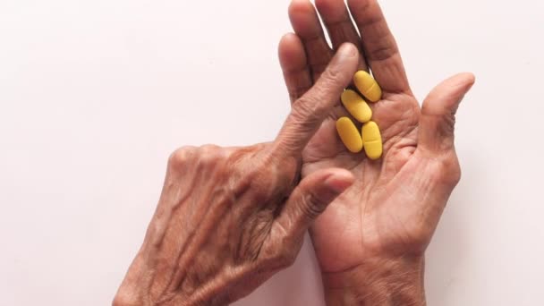  seniorenhanden die medicijnen nemen, close up  - Video