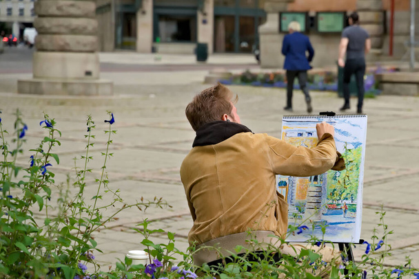 男は市庁舎の絵を描いている。高品質の写真 - 写真・画像