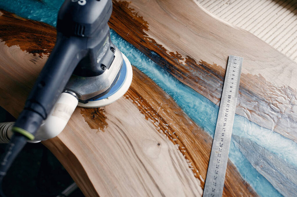 Man is processing with wood by polishing machine - Foto, Bild