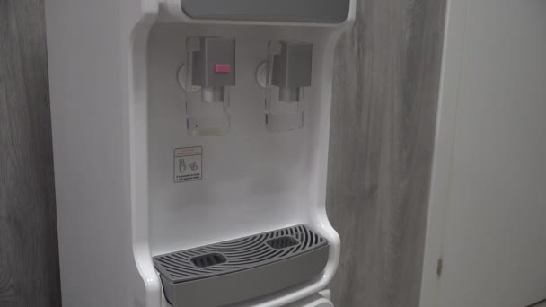 válvula de prensa de dedo en dispensador de filtro de agua de oficina Purificador. El agua está vertiendo - Metraje, vídeo
