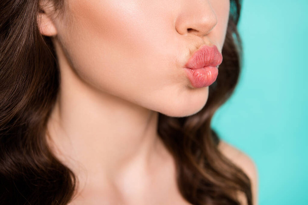 Closeup cropped photo of beautiful curly lady demonstrating allure plump tender lips mouth send kisses shape correction procedure isolated teal color background - 写真・画像