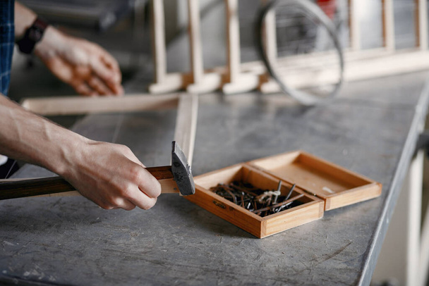 Carpenter hammering a nail in a workshop - Valokuva, kuva